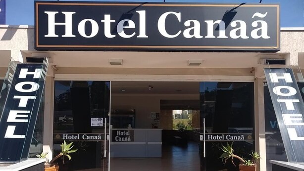 The entrance to Hotel Canaã with a reception desk and potted plants. - Hotel Canaã Express (Jarinu)