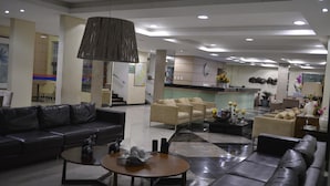 A modern hotel lobby with leather sofas, a coffee table, and a large pendant light. - Hotel Rio Parnaiba (Floriano)