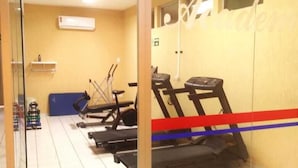 A gym with exercise equipment, a wall-mounted air conditioner, and a tiled floor. - Hotel Rio Parnaiba (Floriano)