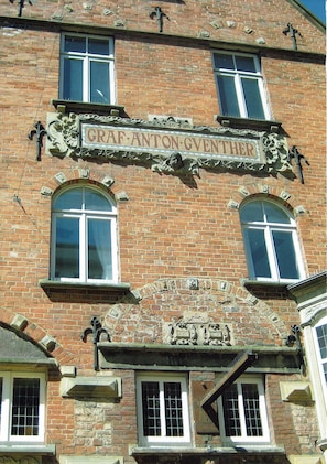 En byggnad av tegel med en skylt som visar texten: "GRAF ANTON GVENTHER".