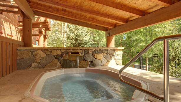 A hot tub under a wooden pergola with stone walls and a metal ladder. - Heart Of River Run & Spacious 2br Premier 2 Bedroom Condo by RedAwning (Keystone)
