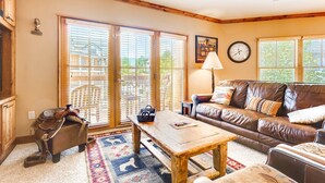 A cozy living room with a leather sofa, a wooden coffee table, and a horse saddle. - Heart Of River Run & Spacious 2br Premier 2 Bedroom Condo by RedAwning (Keystone)