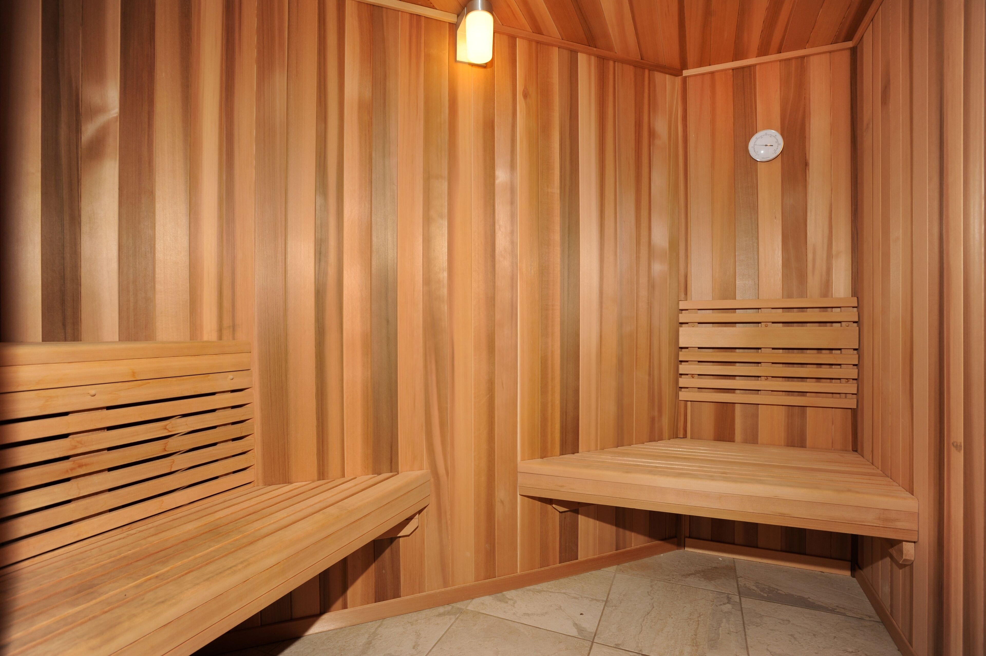A wooden sauna with benches and a light fixture.