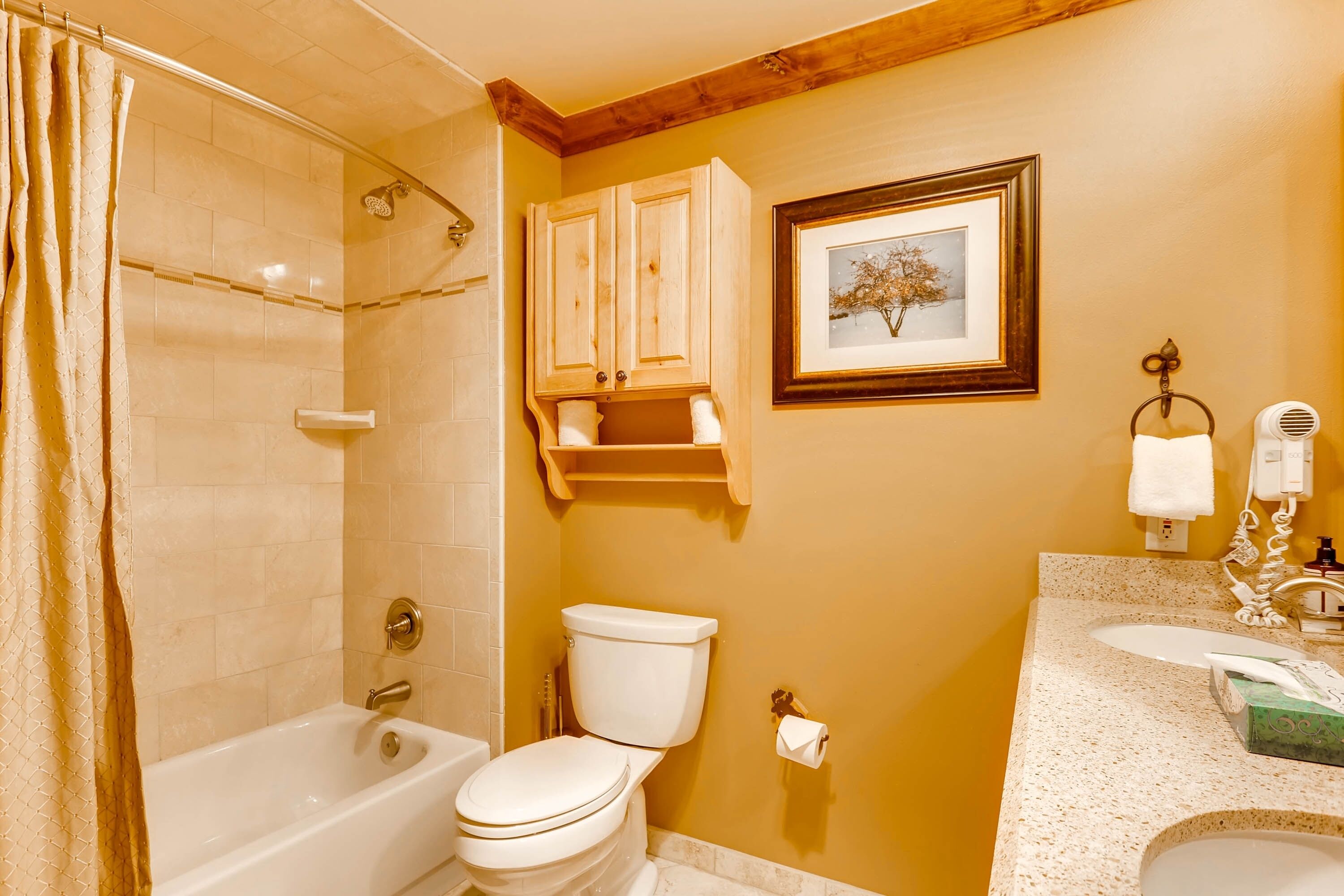 A bathroom with a bathtub, toilet, and sink.
