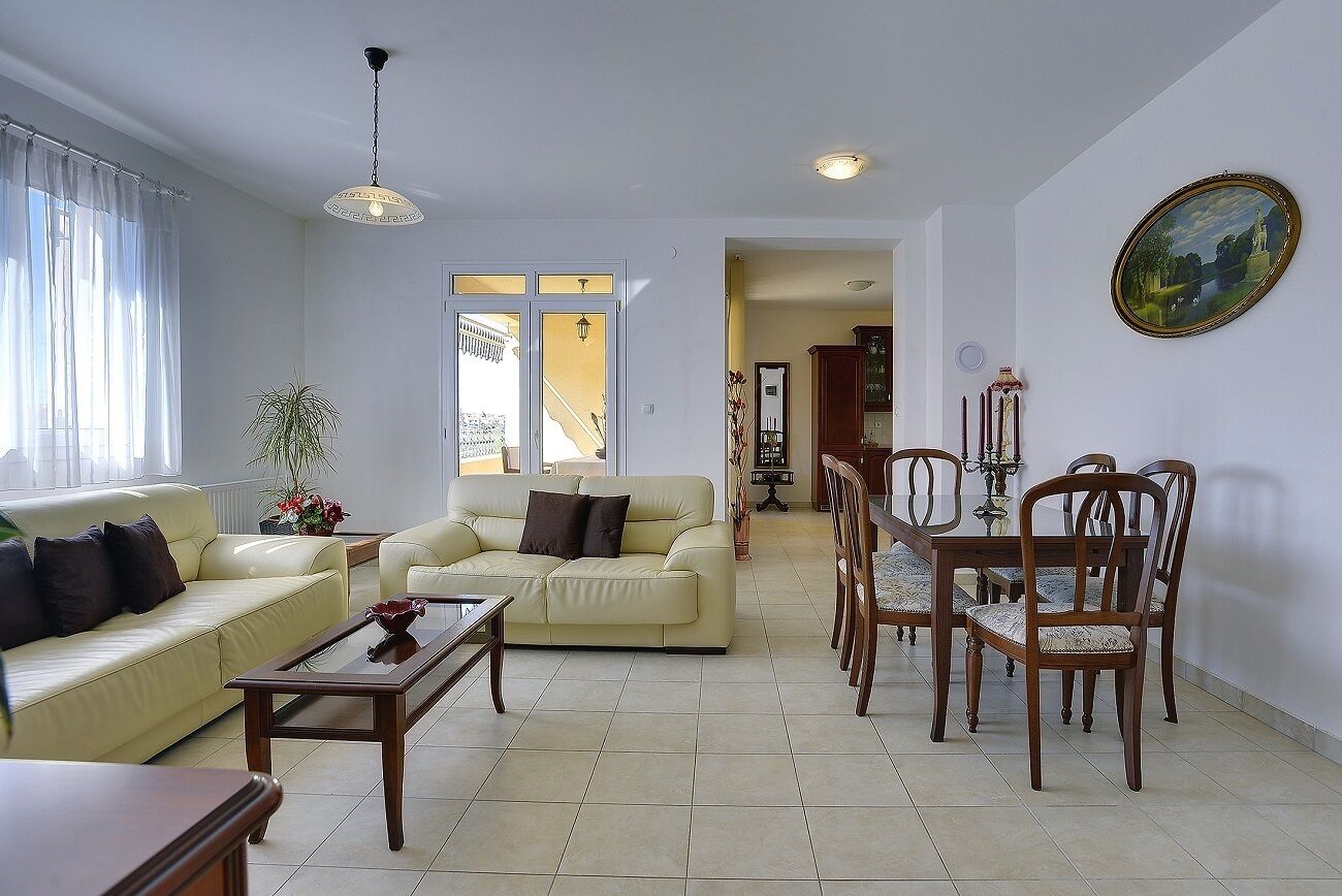 A living room with a sofa, coffee table, and dining table with chairs.