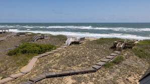 A beach with wooden walkways and structures leading to the ocean.