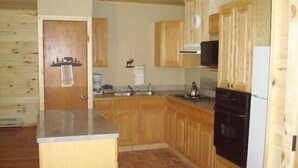 A kitchen with wooden cabinets, a stove, a microwave, and a refrigerator. - Soltow's Place - Wonderful Duplex with Room For Everyone (Lake City)