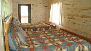 A cabin with two beds, wooden walls, a door, and windows. - Soltow's Place - Wonderful Duplex with Room For Everyone (Lake City)
