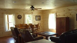 A cozy cabin-style room with a dining area, a sofa, and a ceiling fan. - Soltow's Place - Wonderful Duplex with Room For Everyone (Lake City)
