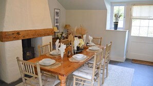 Ein Esszimmer mit einem Holztisch, gedeckt für sechs Personen, umgeben von sechs Stühlen.