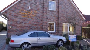 A brick building with a car parked in front. - Stylish and native: The tastefully furnished semi-detached house provides a (Carolinensiel)