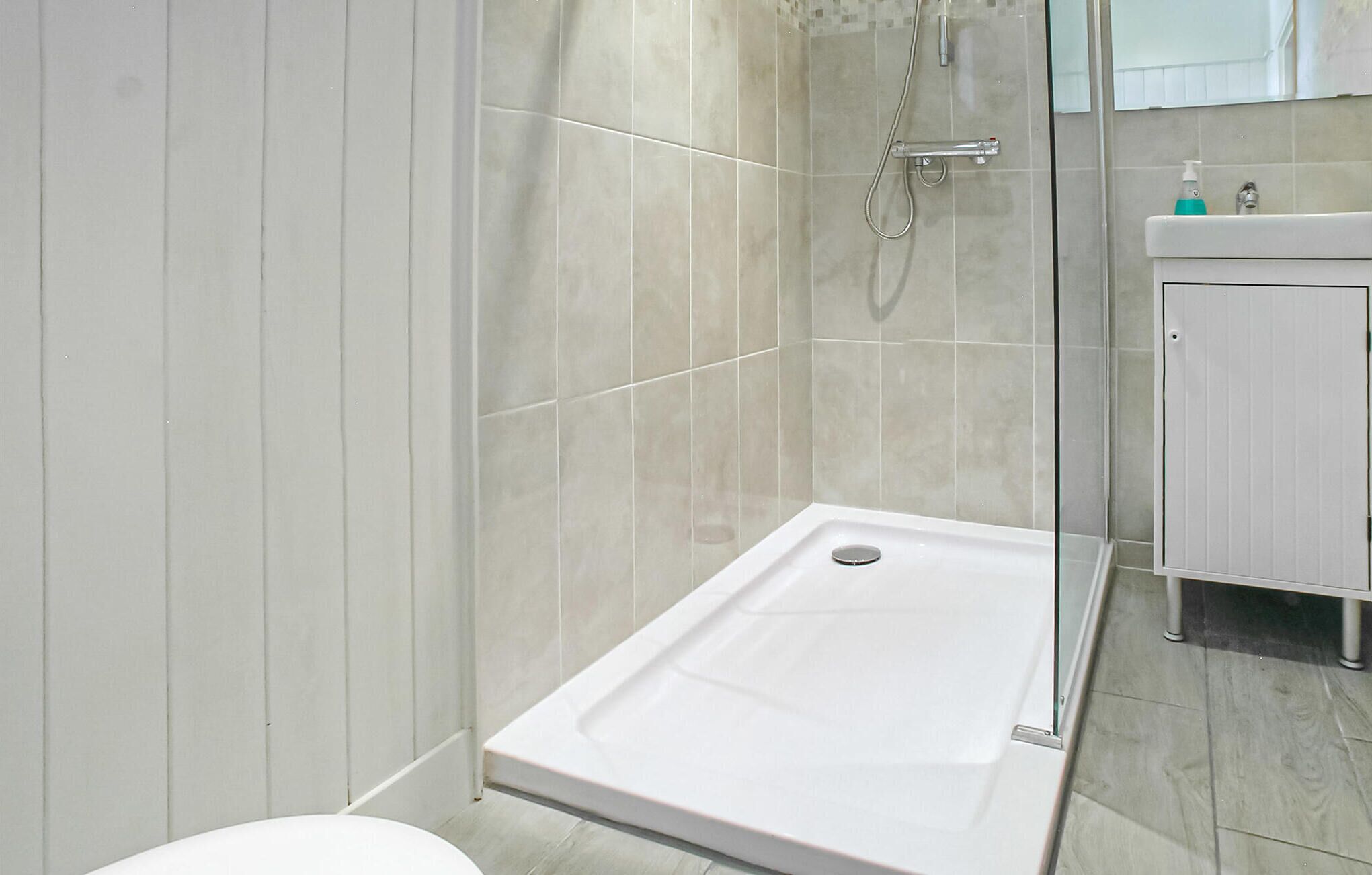 Une salle de bain moderne équipée d’une douche, de toilettes et d’un lavabo.