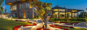 A modern hotel with a well-maintained garden, a lobby area, and a building with multiple windows.