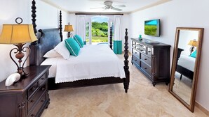 Une chambre à coucher avec un lit à baldaquin, une télévision, une commode et un grand miroir.