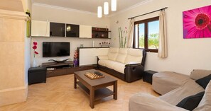 A living room with a sofa, a coffee table, a TV, and a cabinet. - Can Olivaret 419 fantastic finca with private pool, terrace, barbecue and WiFi (Campos)