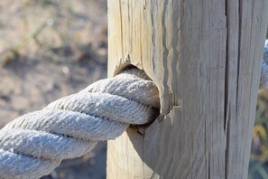 Un gros plan d’une corde enroulée autour d’un poteau en bois.