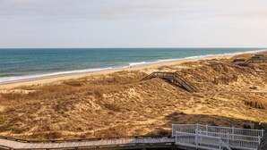 A beach with a wooden boardwalk leading to a sandy area with dunes. - FFR309 - Beach Bliss by FIrst Flight Rentals (Kill Devil Hills)