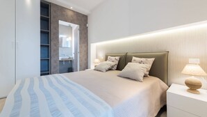 A modern bedroom with a bed, bedside tables, a wardrobe, and a bathroom with a mirror. - Villa Licia - Villa with pool by the beach (Santa Maria del Focallo)