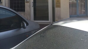 A building with a ground-floor entrance, a balcony, and a car parked in front. - Themis (Cannes)