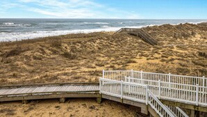 A beach with a wooden boardwalk and a white railing. - FFR211 Atlantic View Retreat by First Flight Rentals (Kill Devil Hills)