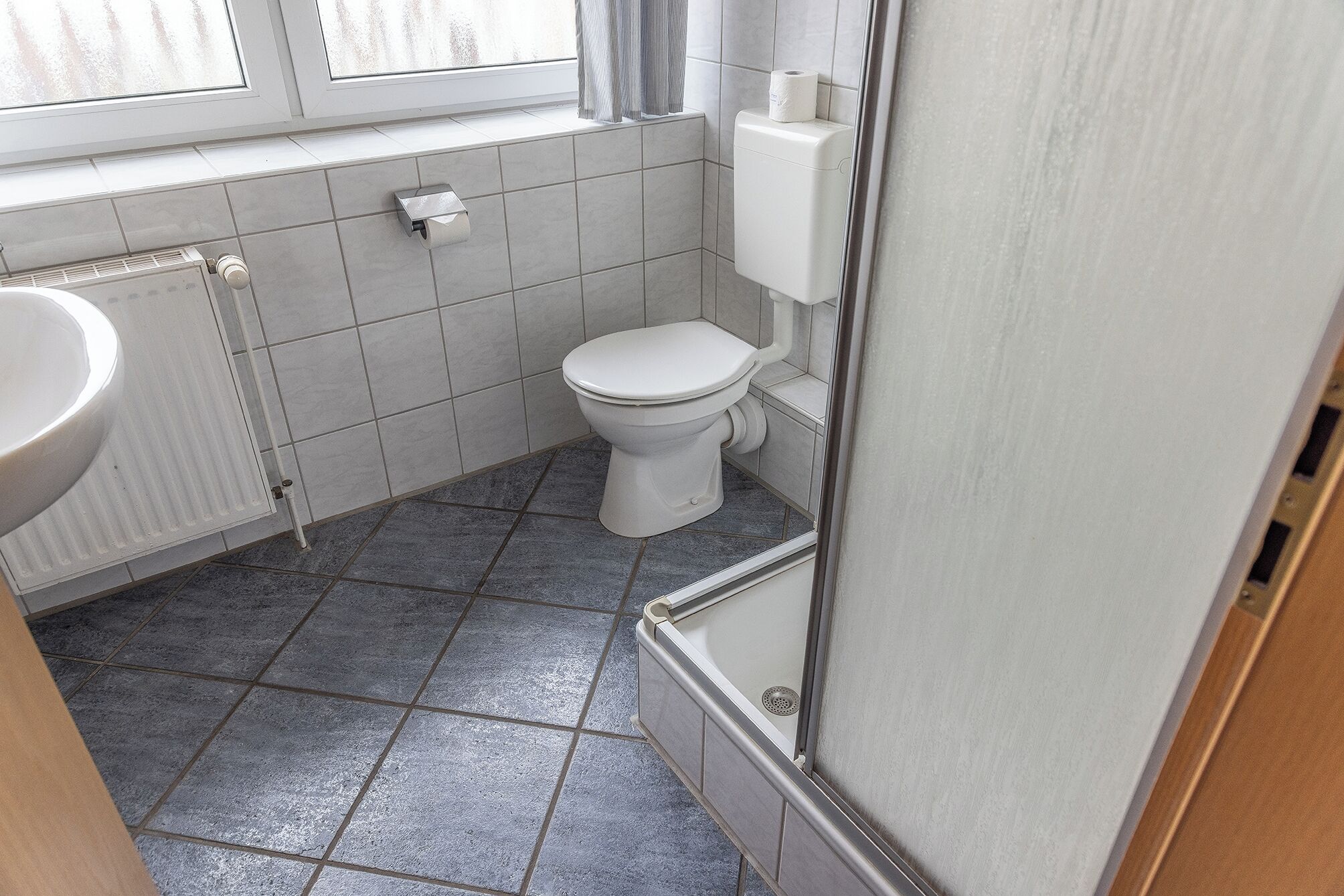Un baño pequeño con inodoro, lavabo y ventana.