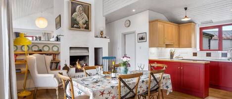Un comedor con una mesa dispuesta para cuatro personas, rodeada de sillas de madera.