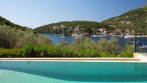 A pool with a view of a marina and hills in the background. - Villa Sivota, Exclusive sea front Villa with 99" Underground Cinema (Sivota)