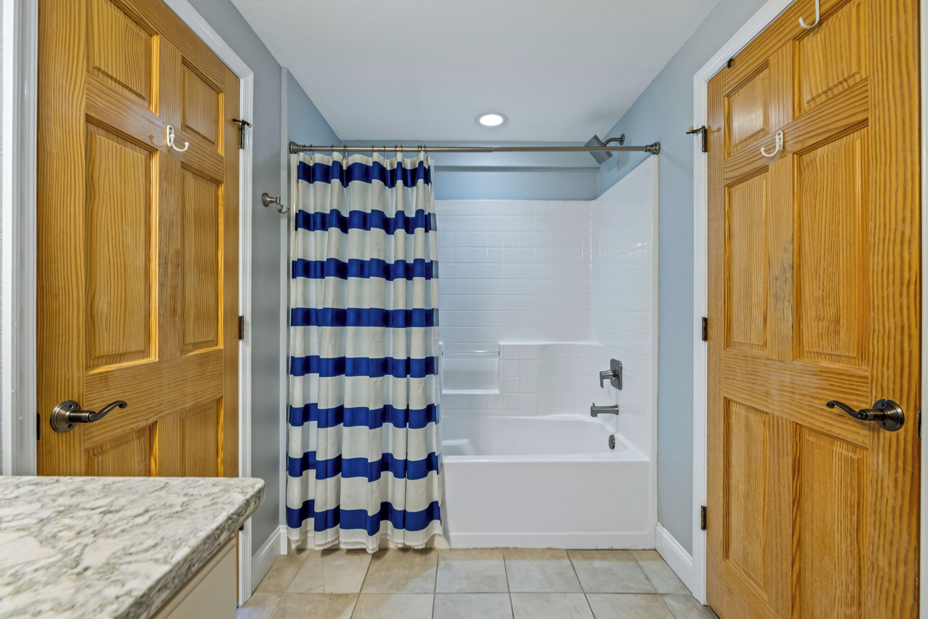 Un bagno con doccia, vasca e porte in legno.