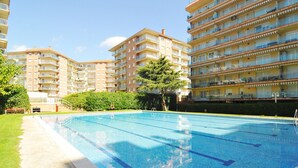 A swimming pool surrounded by multi-story residential buildings with balconies. - HomeHolidaysRentals Solmar - Costa Barcelona (Santa Susana)