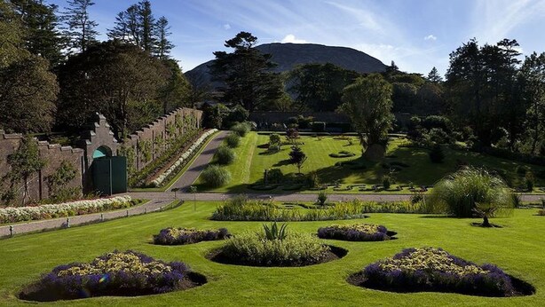 A well-maintained garden with manicured lawns, flower beds, and a stone pathway leading to a gate. - Atlantic Sunset,  Aughris is a home away from home (Cleggan)