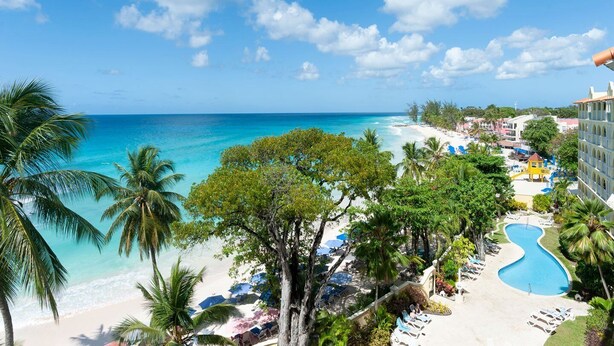 A resort with a pool, beach, and ocean view. - Modern Beachfront Condo with Pool - Sapphire 211 (Saint Lawrence Gap)