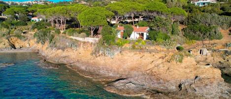 Una proprietà costiera con un litorale roccioso, mare cristallino e vegetazione rigogliosa.