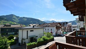 Ein Wohngebiet mit modernen und traditionellen Gebäuden, einem klaren Himmel und Bergen im Hintergrund.