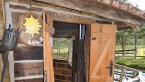 En enkel, rustik stuga byggd av trä, med en trädörr och en liten veranda.