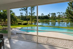 Une piscine avec vue sur un terrain de golf et un lac.