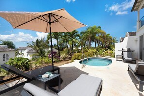 A poolside area with lounge chairs, a table with a book, and a pool. - Sunset Views and Private Pool - Sugar Cane 1 (Westmoreland)