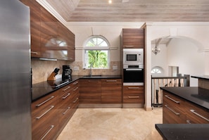 Una cocina moderna con armarios de madera, horno integrado y ventana que proporciona luz natural.
