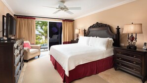A hotel room with a bed, a chair, a dresser, a television, and a ceiling fan. - Sunset Views and Private Pool - Sugar Cane 1 (Westmoreland)