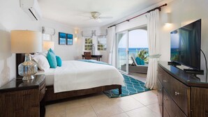 Una camera d'albergo con un letto, una televisione, un balcone con vista e una ventola a soffitto.
