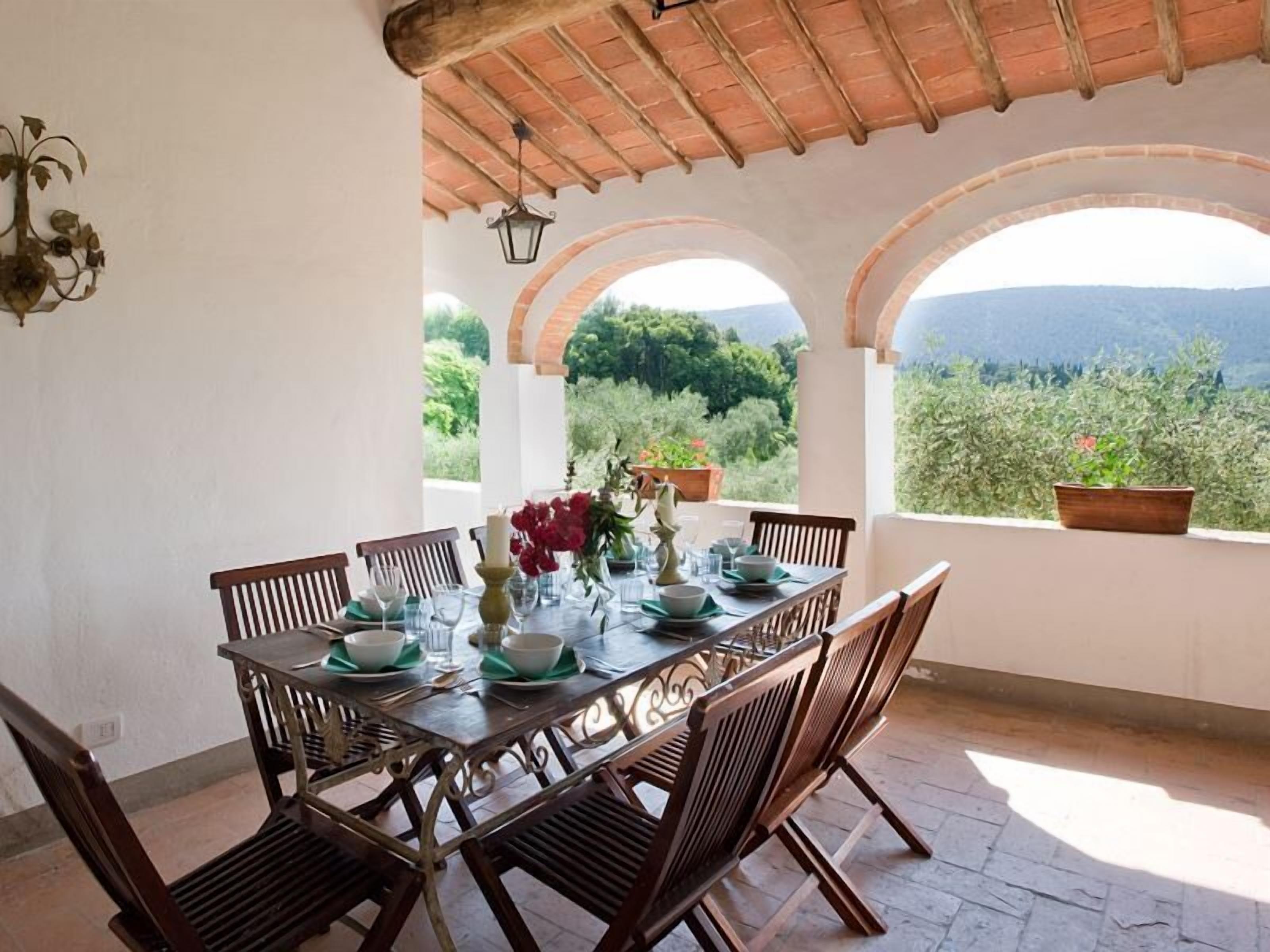 A dining table set for four with a view of the countryside.