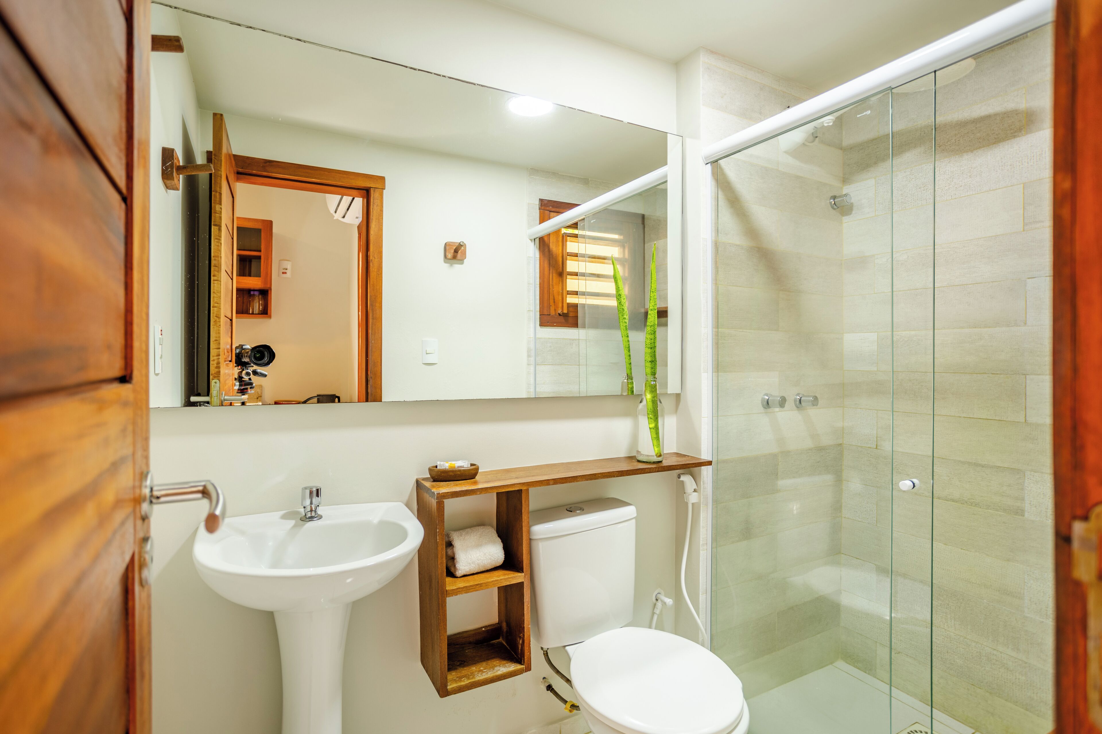 Een badkamer met een witte wastafel, toilet en douchecabine.