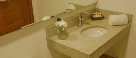 A bathroom with a toilet, sink, and mirror.