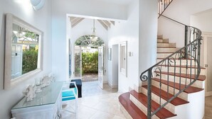 A staircase with a curved design and a metal railing, leading to an upper floor. - Beachfront Bliss with Plunge Pool - Seashells (Paynes Bay)
