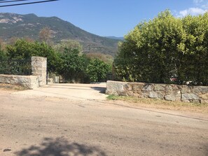 Un camino pavimentado que conduce a una puerta de piedra con una montaña de fondo.