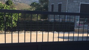 Ein Gebäude mit einer Stein-Fassade und einem Ziegeldach, umgeben von einem eingezäunten Bereich mit freiem Blick auf die umliegende Landschaft.