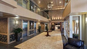 Un vestíbulo de hotel espacioso con un techo alto, una mesa central y una zona de estar.