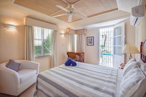 Une chambre d’hôtel avec un lit, une chaise, un bureau et une vue sur une piscine.