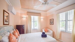 Ein Hotelzimmer mit Bett, Sessel, Kommode und Deckenventilator.