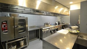 Une cuisine moderne dotée d’appareils électroménagers en acier inoxydable, d’un grand îlot central et d’une disposition fonctionnelle de qualité professionnelle.