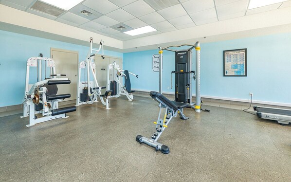 A gym with exercise equipment, a treadmill, and a wall-mounted calendar.